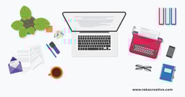 An illustration of a journalist's desk, featuring a laptop, typewriter, and writing utensils